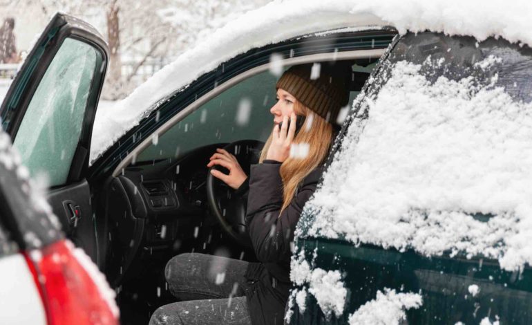 Autofahren im Winter, Frau sitzt in verschneitem Auto