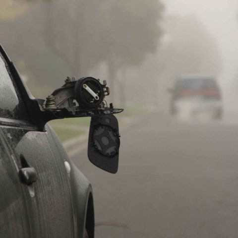 Auto begeht Fahrerflucht, im Vordergrund sieht man den kaputten Spiegel