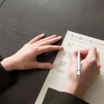 Frau unterschreibt Vertrag über die Erbschaftsteuer