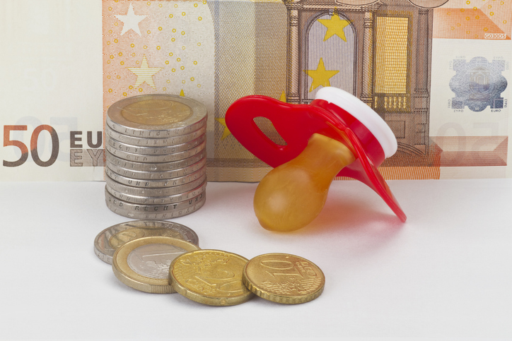 Ein Schnuller liegt neben Münzen und einem 50-Euro-Schein