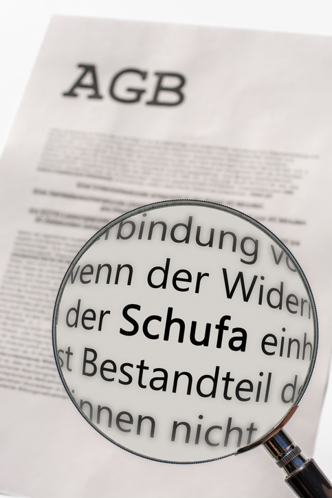 Neuerungen März 2026: Ausgedruckte AGB und eine Lupe, die das Wort Schufa hervorhebt.