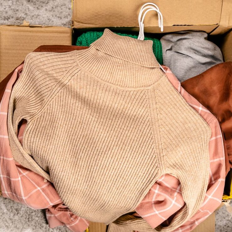 Mehrere Pullover auf Kleiderbügeln in einem Paket eines China fake Shops