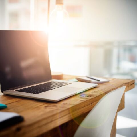 Homeoffice beendet: Ein nicht besetzter Schreibtisch mit einem aufgeklappten, aber ausgeschaltetem Laptop.