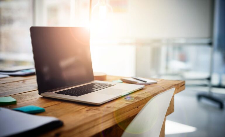 Homeoffice beendet: Ein nicht besetzter Schreibtisch mit einem aufgeklappten, aber ausgeschaltetem Laptop.