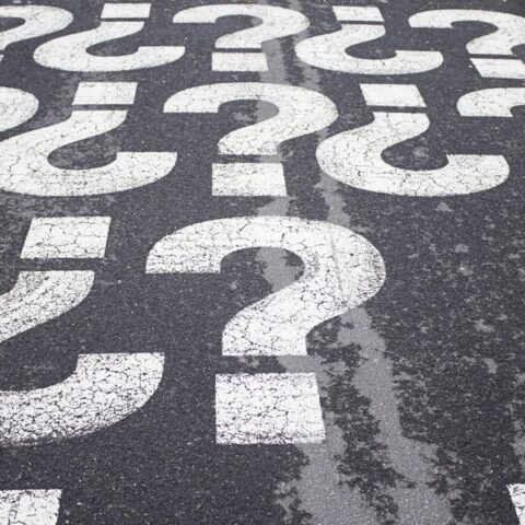 Fragezeichen in weiß auf einer Straße symbolisieren Irrtümer im Straßenverkehr