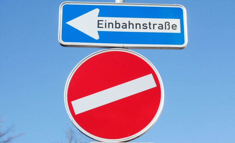 Irreführende Verkehrrsschilder, ein Einbahnstraßenschild und ein schiefes Einfahrt verboten Schild.
